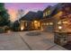 Spacious three-car garage with a circular driveway, illuminated by stylish outdoor lighting at 595 Legacy Falls N Dr, Chapel Hill, NC 27517