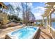 Inviting backyard hot tub featuring deck, lake views, and beautiful landscaping at 595 Legacy Falls N Dr, Chapel Hill, NC 27517