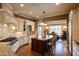 Bright kitchen featuring custom white cabinets, granite countertops, an island with seating, and stainless steel appliances at 595 Legacy Falls N Dr, Chapel Hill, NC 27517