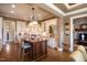 Open kitchen with a large island, custom cabinets, granite counters, stainless appliances, and easy access to other rooms at 595 Legacy Falls N Dr, Chapel Hill, NC 27517