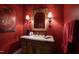Chic powder room featuring textured red walls, a detailed vanity, and ornate mirror at 595 Legacy Falls N Dr, Chapel Hill, NC 27517