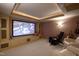Cozy theater room with a projector, cushioned seating, and custom built-ins at 595 Legacy Falls N Dr, Chapel Hill, NC 27517