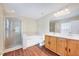 Bright bathroom featuring a glass shower, soaking tub, double vanity, and wood flooring at 619 Ashburn Ln, Durham, NC 27703
