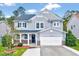 Charming two-story home with gray siding, a well-manicured lawn, and attached two car garage at 619 Ashburn Ln, Durham, NC 27703