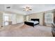 Spacious main bedroom featuring tray ceilings, a ceiling fan, and an en-suite bathroom at 619 Ashburn Ln, Durham, NC 27703