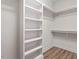 Walk-in closet with custom shelving providing ample storage space, and laminate wood floor at 713 Catherine Lake Ct, Fuquay Varina, NC 27526