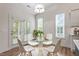 Bright dining area featuring a round glass table with modern white chairs and views to the backyard at 713 Catherine Lake Ct, Fuquay Varina, NC 27526