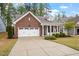 Charming single-Gathering home featuring a brick facade, well-manicured lawn, and two-car garage at 713 Catherine Lake Ct, Fuquay Varina, NC 27526