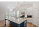 Bright open kitchen with a center island, stainless appliances, and modern lighting at 713 Catherine Lake Ct, Fuquay Varina, NC 27526