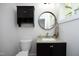 Charming bathroom features granite counters, custom dark cabinets and modern, round mirror at 808 Grace Ave, Burlington, NC 27217