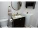 This elegant bathroom features granite counters, custom dark cabinets and a modern, round mirror at 808 Grace Ave, Burlington, NC 27217