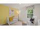 Cozy Bedroom featuring a crib, rocking chair, and window with natural light at 812 Canis Minor Rd, Wendell, NC 27591