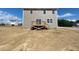 View of the back of a house with beige siding, a deck, and an unfinished backyard at 84 Grove Township Way, Angier, NC 27501