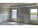 Bedroom with light gray walls, two windows providing natural light, and unfinished floors at 84 Grove Township Way, Angier, NC 27501