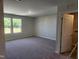 Large bedroom with plush carpeting, ample natural light, and access to a laundry area at 84 Grove Township Way, Angier, NC 27501