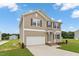 Inviting two-story home with a two-car garage, manicured lawn, and a welcoming entrance at 84 Grove Township Way, Angier, NC 27501