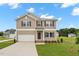 Charming two-story home with neutral siding, a two-car garage, and a well-maintained front yard at 84 Grove Township Way, Angier, NC 27501