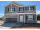 Two-story home with gray siding, black shutters, a large front-facing garage, and a light-colored front door at 84 Grove Township Way, Angier, NC 27501