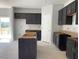 Partially finished kitchen with dark cabinets, a center island, and a door leading to a back deck at 84 Grove Township Way, Angier, NC 27501