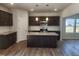 Well-equipped kitchen featuring pendant lighting, granite counters, dark cabinets, and stainless steel appliances at 84 Grove Township Way, Angier, NC 27501
