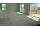 Bright, unfinished living room featuring large windows and sliding glass doors to the outdoor deck at 84 Grove Township Way, Angier, NC 27501