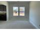 Open-concept living room with natural light, neutral walls, and a view to exterior of the house at 84 Grove Township Way, Angier, NC 27501