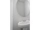 New powder room featuring pedestal sink, round mirror and fresh neutral paint at 84 Grove Township Way, Angier, NC 27501