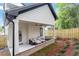 This outdoor sofa on a covered patio overlooks the landscaped backyard at 1007 E Davie St, Raleigh, NC 27601