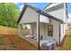 This covered patio features an outdoor sofa and an enclosed backyard at 1007 E Davie St, Raleigh, NC 27601