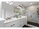 Bathroom featuring a dual sink vanity, and a glass-enclosed shower with tile surround at 1007 E Davie St, Raleigh, NC 27601