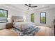 Bright primary bedroom featuring a tray ceiling, ceiling fan, and windows at 1007 E Davie St, Raleigh, NC 27601