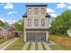 This three-story brick home has a modern garage door and manicured front yard at 1007 E Davie St, Raleigh, NC 27601