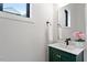 Stylish powder room featuring a green vanity and decorative mirror at 1007 E Davie St, Raleigh, NC 27601