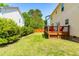 Serene backyard with a spacious wooden deck, bordered by lush greenery and a wooden fence at 101 Vista Brooke Dr, Morrisville, NC 27560