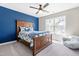 Cozy bedroom with blue accent wall, wood furniture, and a ceiling fan at 101 Vista Brooke Dr, Morrisville, NC 27560