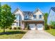 Charming two-story home featuring a stone facade, gabled roof, and a two-car garage at 101 Vista Brooke Dr, Morrisville, NC 27560