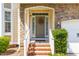 Charming home entrance with stone accents, wreath, and brick steps, offering a welcoming curb appeal at 101 Vista Brooke Dr, Morrisville, NC 27560