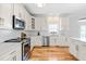 Modern kitchen with stainless steel appliances, white cabinets, and hardwood flooring at 101 Vista Brooke Dr, Morrisville, NC 27560