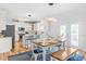 Bright kitchen with stainless appliances, white cabinets, a center island, and a dining area with a wood table at 101 Vista Brooke Dr, Morrisville, NC 27560