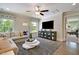 Comfortable living room featuring a ceiling fan, mounted TV, display cabinet, and a large rug, ideal for relaxation at 108 Berry Mill Ln # 132, Raleigh, NC 27603