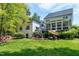 Backyard view of home with lush green lawn, mature landscaping, outdoor seating and screened porch at 111 Finnway Ln, Cary, NC 27519