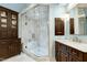 Spacious primary bathroom featuring marble walk-in shower with bench and dark wood vanity with marble counters at 111 Finnway Ln, Cary, NC 27519