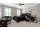 Neutral-toned bedroom featuring two windows, a ceiling fan, a desk, and a chair at 111 Finnway Ln, Cary, NC 27519