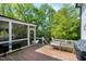 An outdoor deck with a screened-in porch overlooking a lush yard surrounded by mature trees at 111 Finnway Ln, Cary, NC 27519
