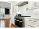 Close up of a gourmet gas cooktop with stainless steel hood and white cabinets at 111 Finnway Ln, Cary, NC 27519