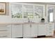 White kitchen featuring stone countertops, white cabinets and a view to the backyard at 111 Finnway Ln, Cary, NC 27519