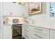 Dry bar in kitchen with beverage fridge, custom cabinets and stone countertop at 111 Finnway Ln, Cary, NC 27519