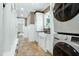 Bright mud room with built-in shelving, a utility sink, and stacked washer and dryer at 111 Finnway Ln, Cary, NC 27519