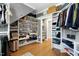 Large walk-in closet with custom shelving and a doorway leading to another room at 111 Finnway Ln, Cary, NC 27519