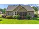 View of the rear exterior featuring a screened porch and fenced yard with manicured lawn at 1141 Contender Dr, Clayton, NC 27520